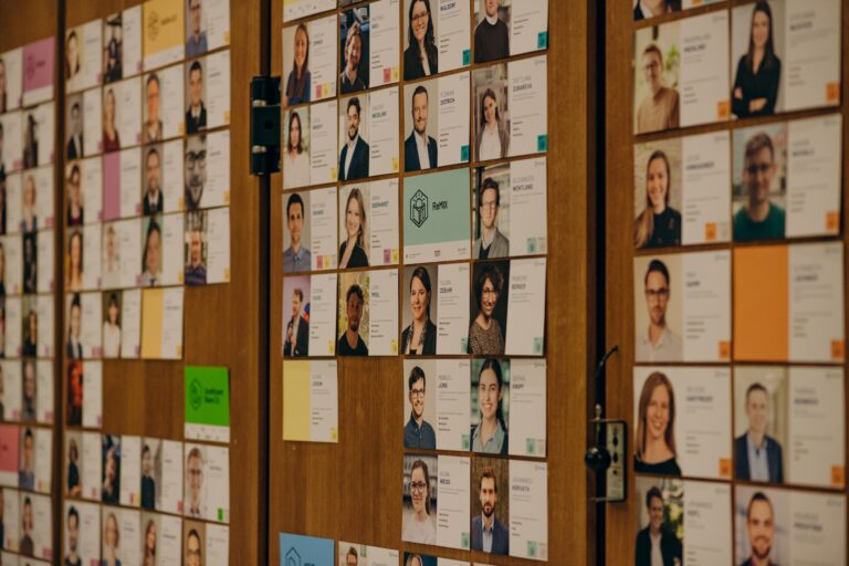 Auf dem Foto sieht man eine Wand mit Steckbriefen von vielen MCube Mitarbeitenden.