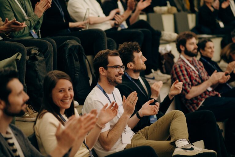 Blick auf klatschende Personen, die im Publikum sitzen.
