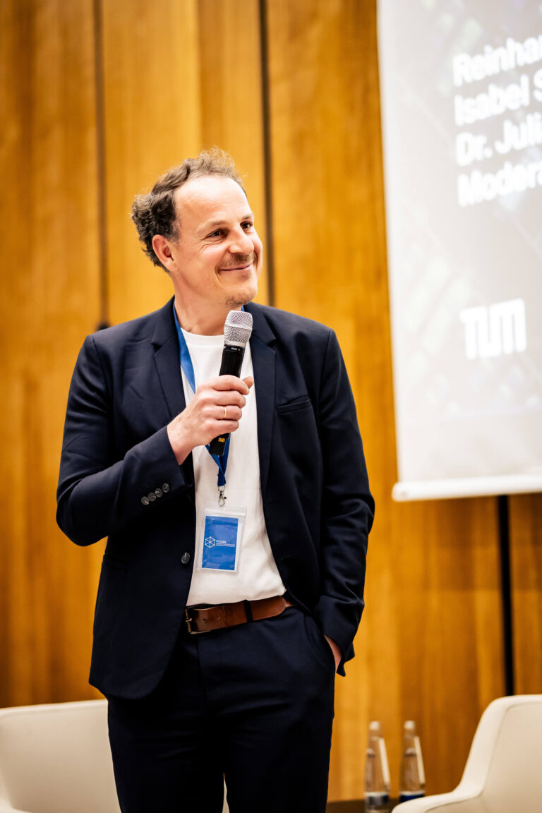 Das Foto zeigt den Geschäftsführer von MCube, Oliver May-Bachmann, der während der 19. Speaker Series eine Rede hält