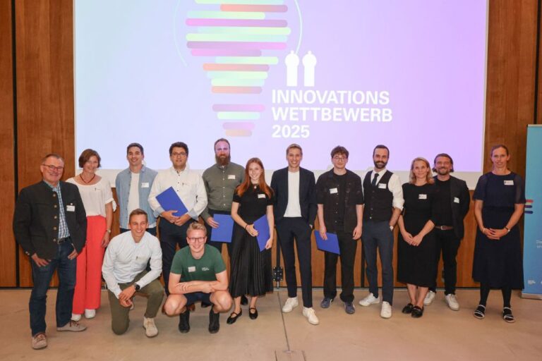 Die Preisträgerinnen und Preisträger des Innovationswettbewerbs 2025 der Stadt München auf der Bühne des Auditoriums im Munich Urban Colab.